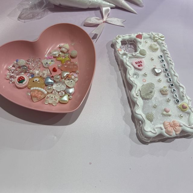 A decoden phone case made at a hens party, spelled out in lettered beads with pearls and shells